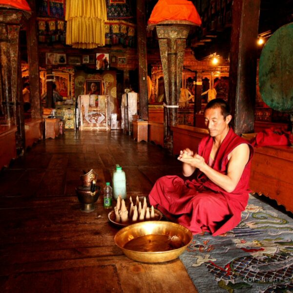 Buddhistický mnich při výrobě modlitebních svíček